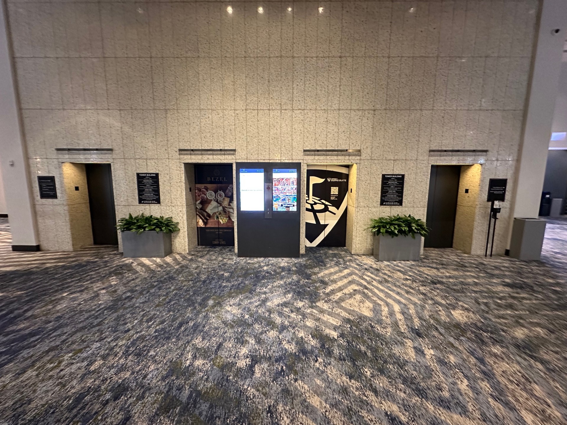 Close-up view of the 4 elevator doors showing different displays and advertisements