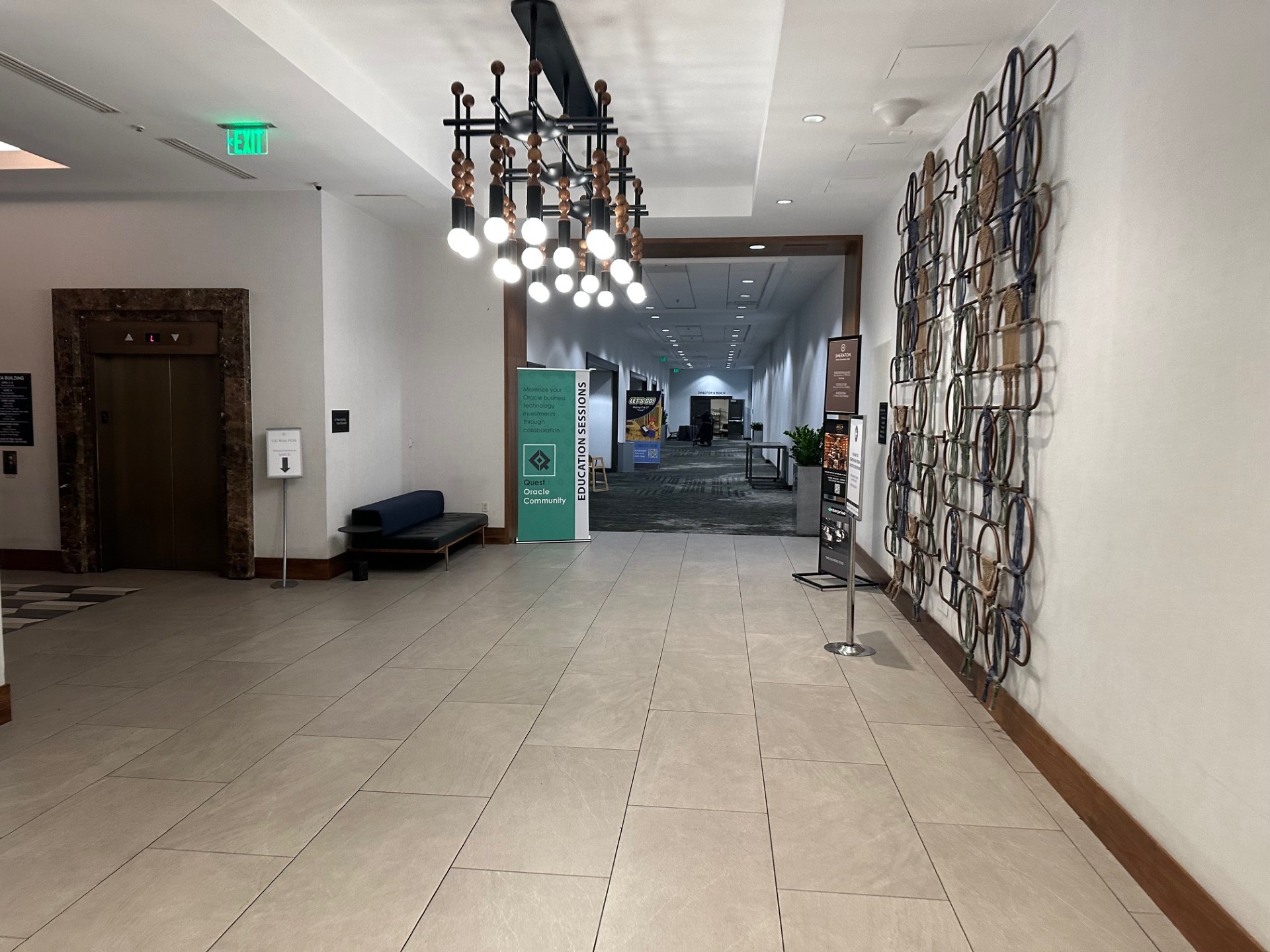 Elegant hotel hallway with decorative chain-link wall art and seating area