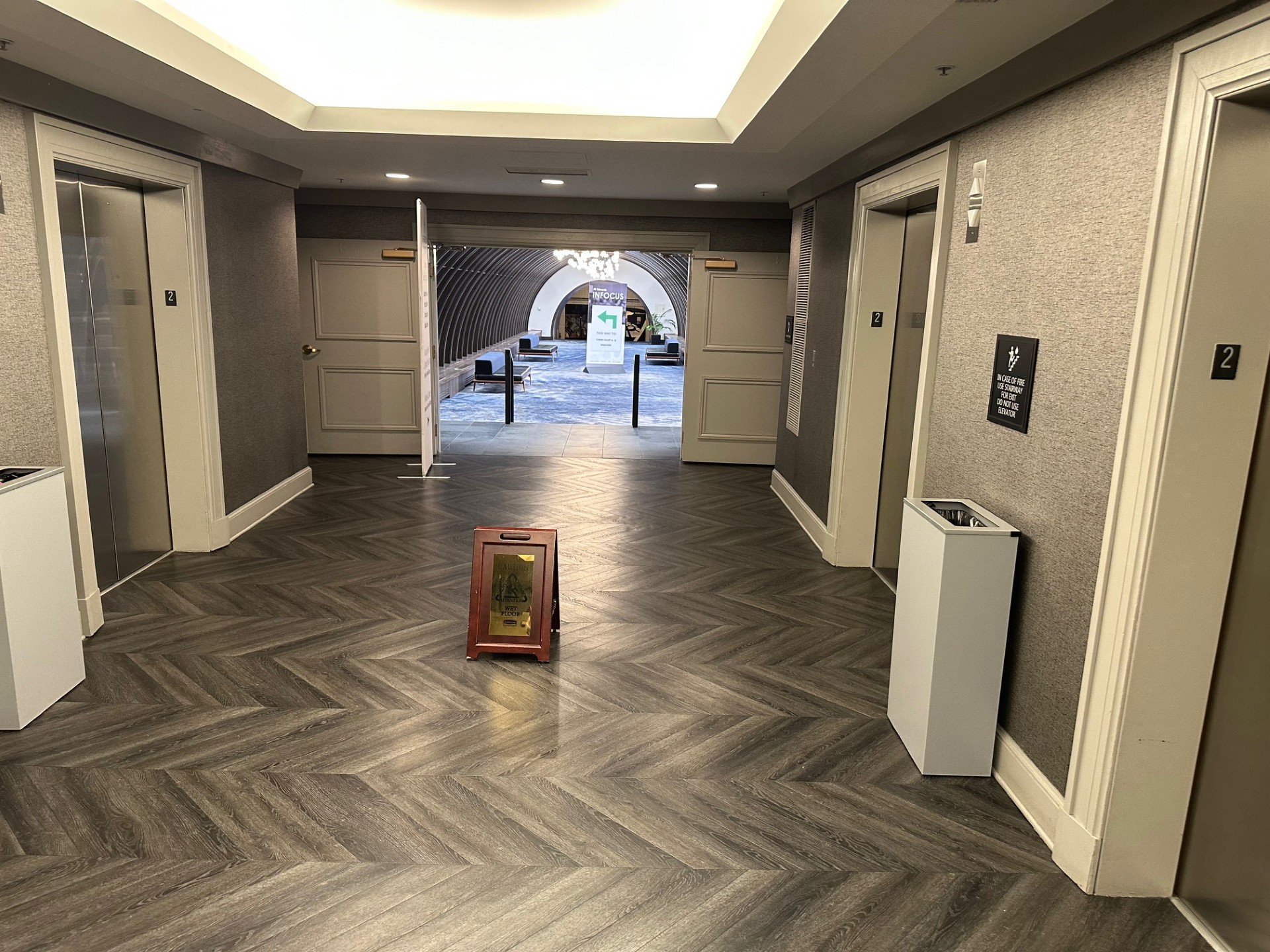 Bank of 4 tower elevators with elegant herringbone flooring and modern design